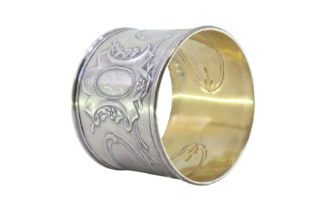 Argola de guardanapo em prata com motivos florais relevados envolvendo cartela para monograma.